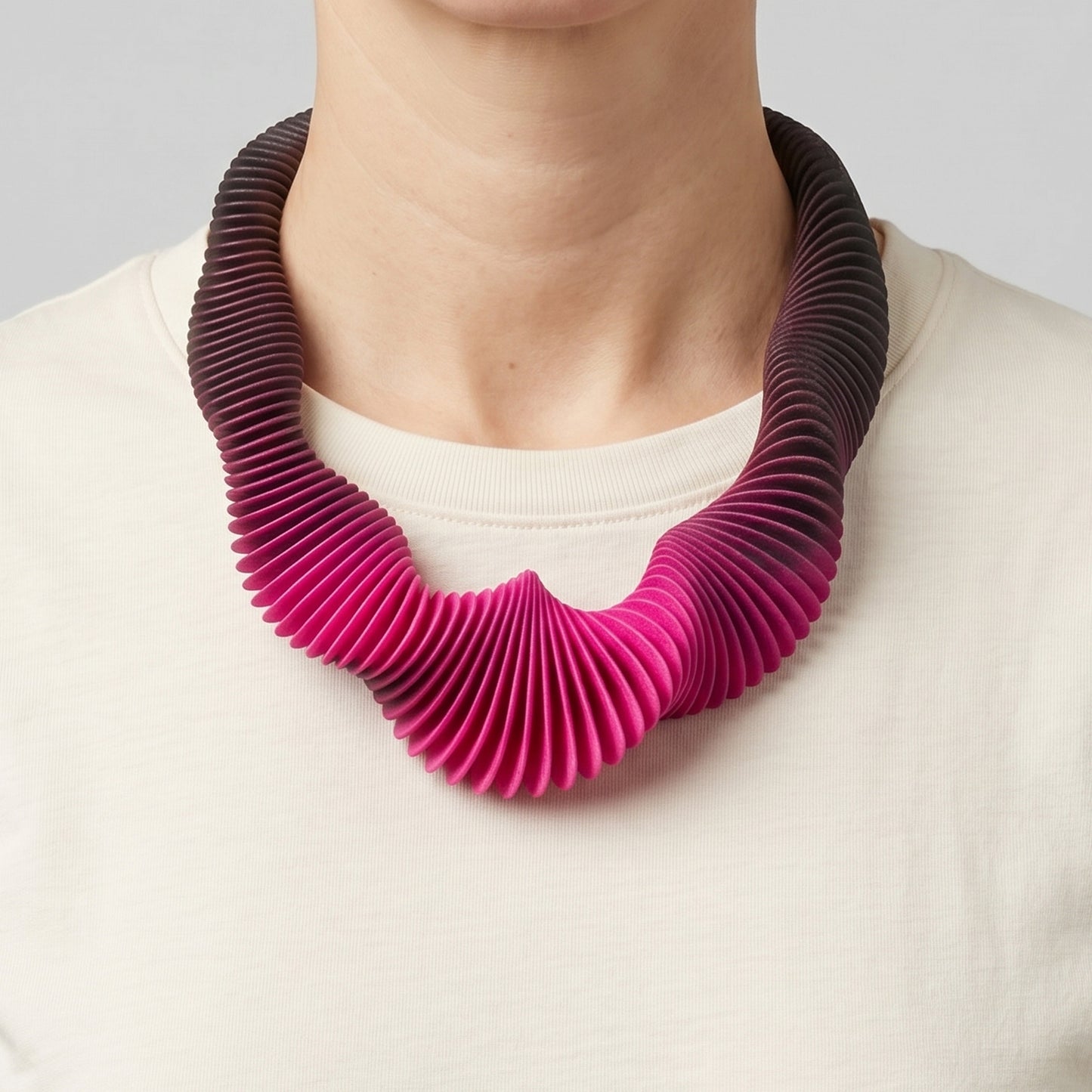 Pink Gradient 3D printed flexible necklace worn by a woman with a cream t-shirt.