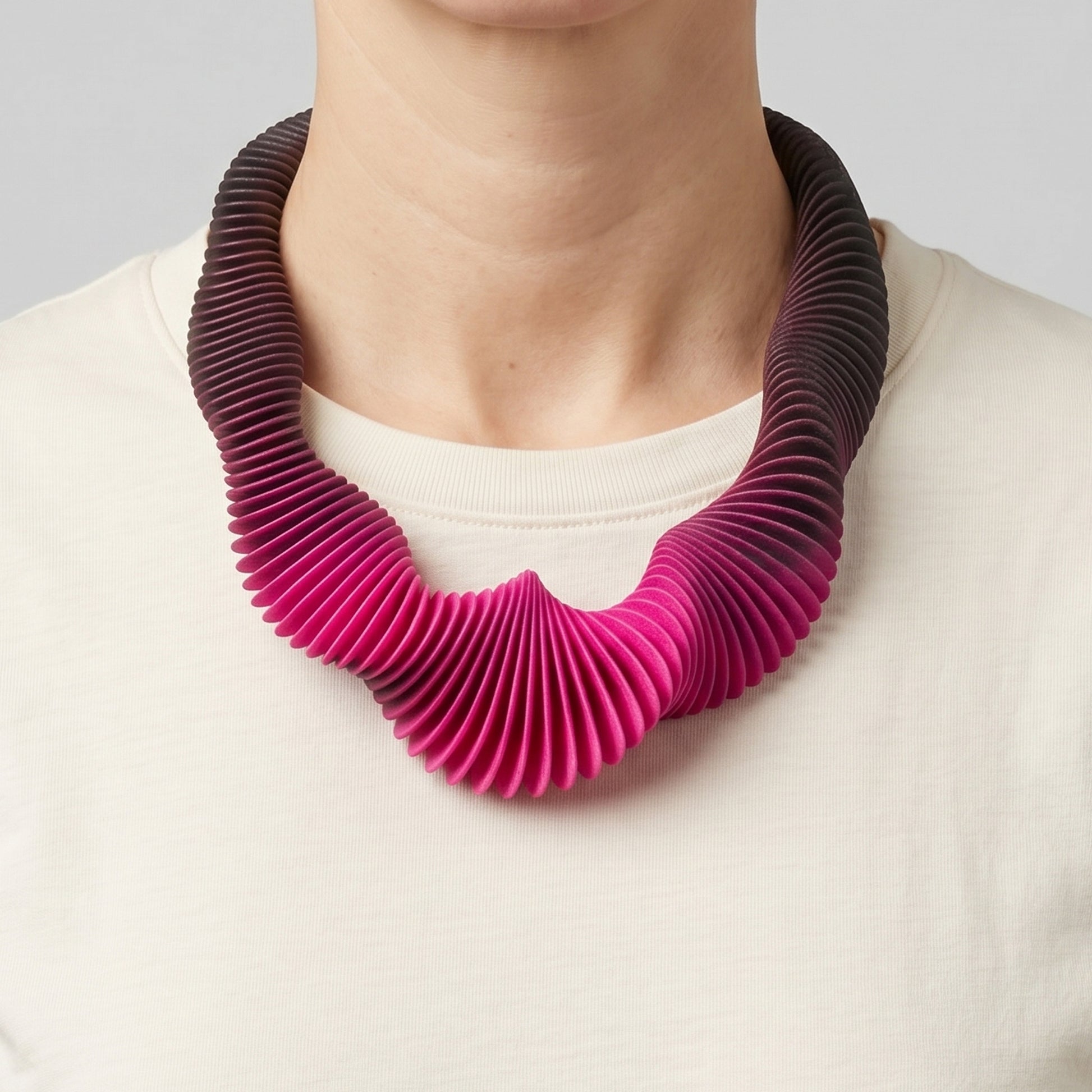 Pink Gradient 3D printed flexible necklace worn by a woman with a cream t-shirt.