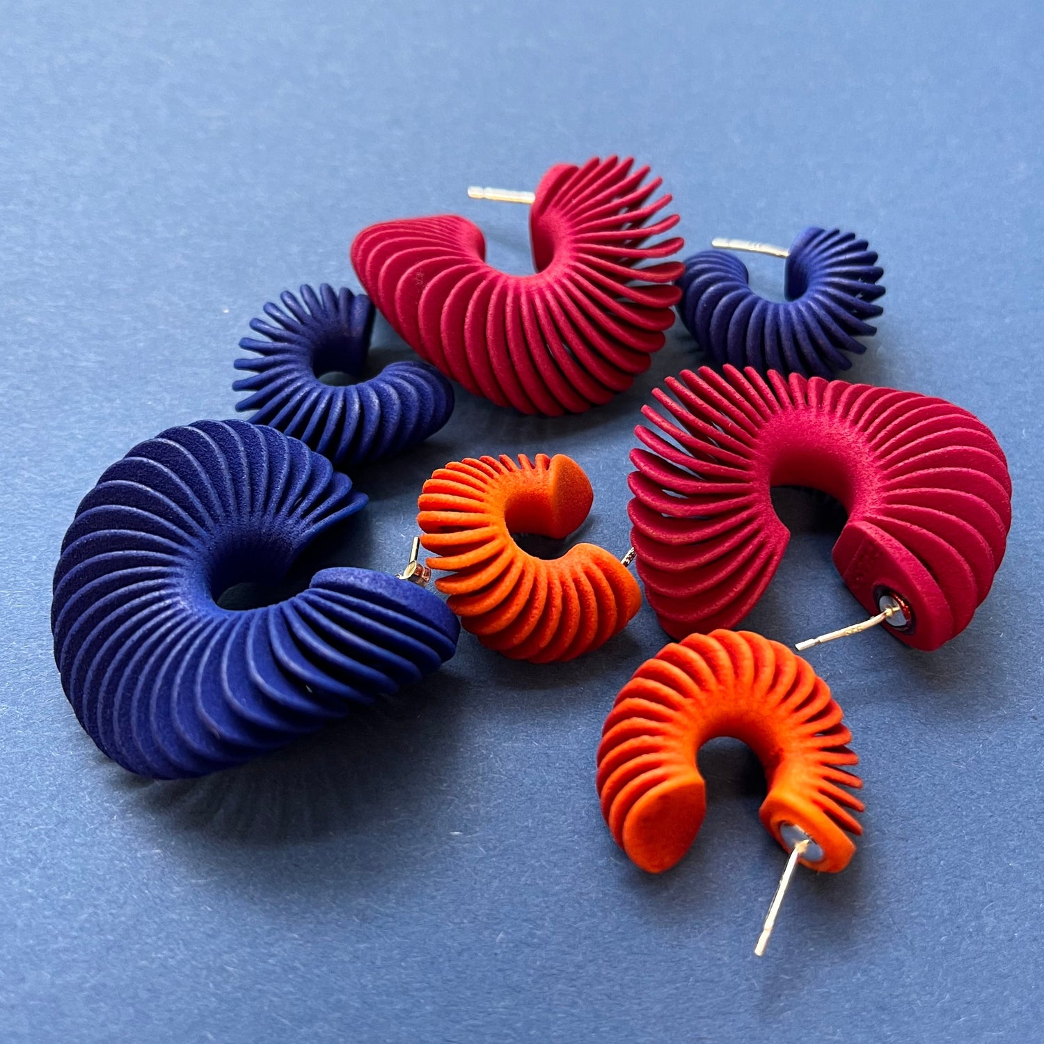 Colorful spiral earrings on a blue background