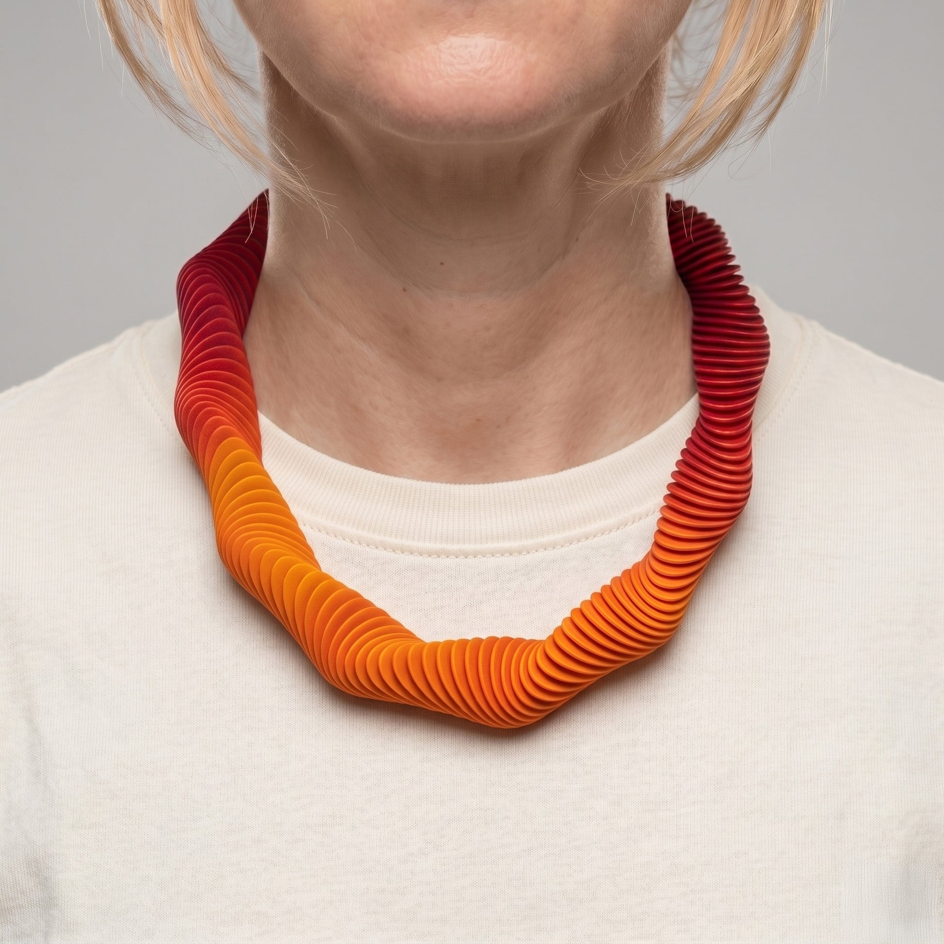 Yellow gradient 3D printed collar necklace with wave form pattern by Phase Jewellery show on neck of woman with cream t-shirt