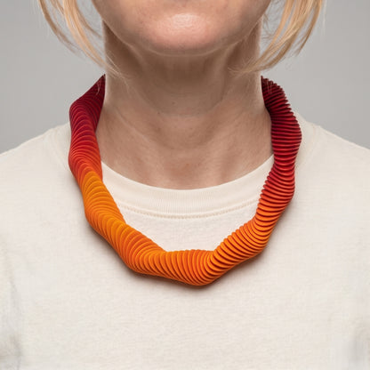 Yellow gradient 3D printed collar necklace with wave form pattern by Phase Jewellery show on neck of woman with cream t-shirt