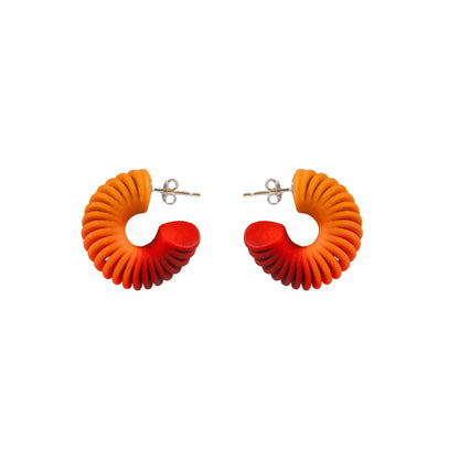 Pair of orange and red 3d printed twisted hoop earrings on a white by Phase Jewellery
